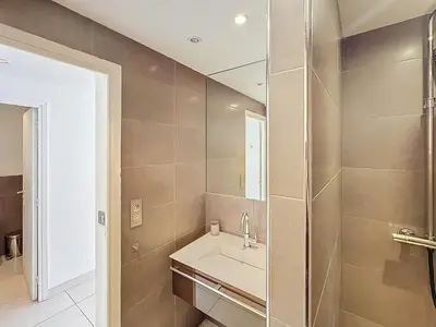 a bathroom with a sink and a mirror at 57m2 - 2 chambres, terrasse, Croisette-Martinez in Cannes