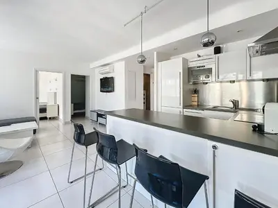 a kitchen with a counter and chairs in it at 57m2 - 2 chambres, terrasse, Croisette-Martinez in Cannes