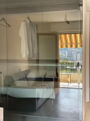 a bedroom with a bed and a glass wall at Appartement Design élégant in Le Cannet