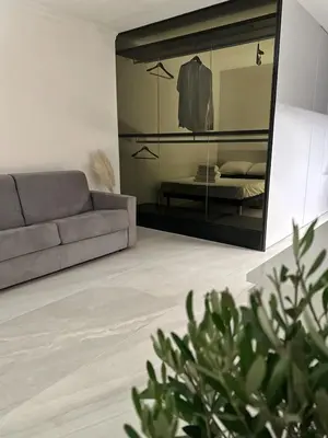 a living room with a couch and a mirror at Appartement Design élégant in Le Cannet