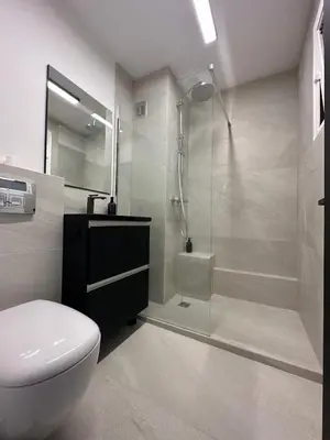 a bathroom with a shower and a toilet and a sink at Appartement Design élégant in Le Cannet