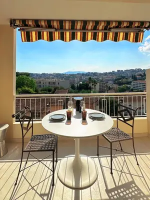 a white table and chairs on a balcony with a view at Appartement Design élégant in Le Cannet