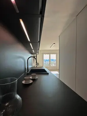 a kitchen with a black counter top and a sink at Appartement Design élégant in Le Cannet