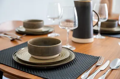 a wooden table with a bowl and plates and wine glasses at Hypercentre - 5mn croisette - Palais - Plage - CF in Cannes