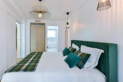 a bedroom with a large bed with green and white pillows at Hypercentre - 5mn croisette - Palais - Plage - CF in Cannes