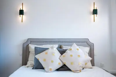 a bed with pillows on it with two lights on it at Hypercentre - 5mn croisette - Palais - Plage - CF in Cannes