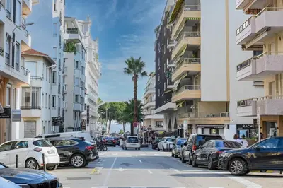 a city street filled with parked cars and palm trees at Hypercentre - 5mn croisette - Palais - Plage - CF in Cannes