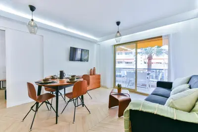 a living room with a table and a couch at Hypercentre - 5mn croisette - Palais - Plage - CF in Cannes