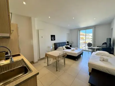 a room with two beds and a kitchen with a sink at Cannes La Croisette - Joli studio au calme coté jardin in Cannes