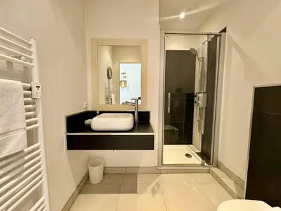 a bathroom with a shower and a sink and a mirror at Cannes La Croisette - Joli studio au calme coté jardin in Cannes