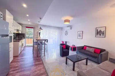 a kitchen and a living room with a couch and a table at LE SURCOUF Appartement by 4 By SUNSET in Le Cannet