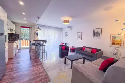 a living room with a couch and a table at LE SURCOUF Appartement by 4 By SUNSET in Le Cannet