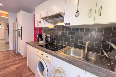 a kitchen with a sink and a washing machine at LE SURCOUF Appartement by 4 By SUNSET in Le Cannet