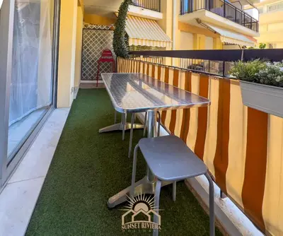 a table and a chair on the side of a balcony at LE SURCOUF Appartement by 4 By SUNSET in Le Cannet