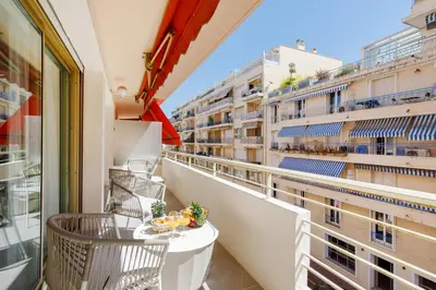 a balcony with chairs and a view of a street at Premium 80sqm Apartment Opposite Martinez, Steps from Congress Center in Cannes