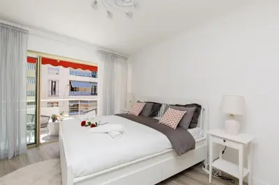a white bedroom with a white bed and a window at Premium 80sqm Apartment Opposite Martinez, Steps from Congress Center in Cannes