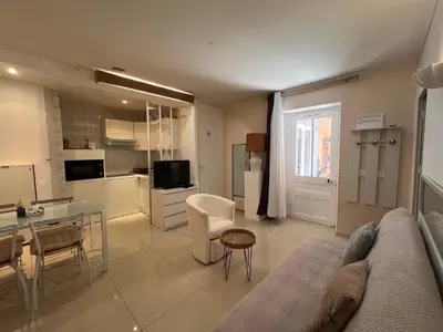 a living room with a couch and a table and a kitchen at B031 2 chambres 6 personnes terrasse au centre historique in Cannes