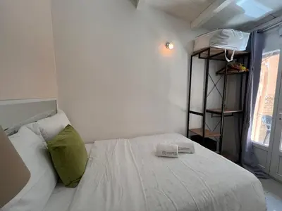 a bedroom with a white bed with a green pillow at B031 2 chambres 6 personnes terrasse au centre historique in Cannes