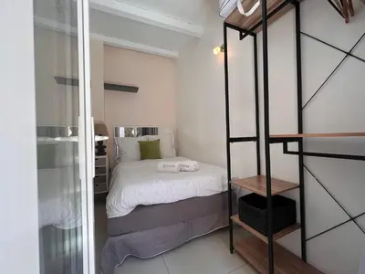 a small bedroom with a bed with white sheets at B031 2 chambres 6 personnes terrasse au centre historique in Cannes