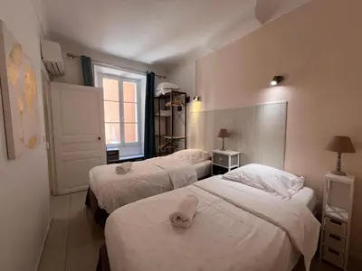 a hotel room with three beds and a window at B031 2 chambres 6 personnes terrasse au centre historique in Cannes