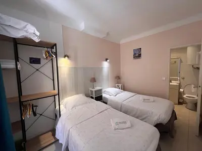a hotel room with two beds and a toilet at B031 2 chambres 6 personnes terrasse au centre historique in Cannes