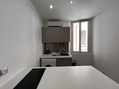 a small kitchen with a white table and a window at B032 Grand studio au marche Forville in Cannes