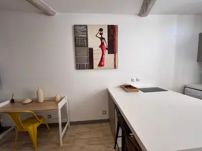 a kitchen with a desk and a table with a picture on the wall at B032 Grand studio au marche Forville in Cannes