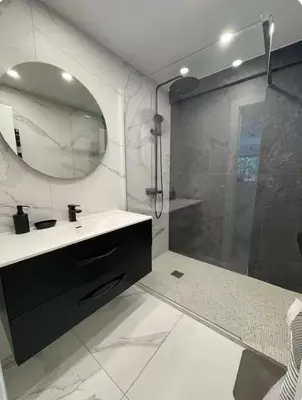 a bathroom with a sink and a shower with a mirror at Oasis by L'Oliveraie in Cannes
