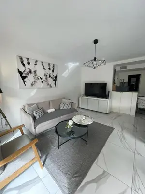 a living room with a couch and a table at Oasis by L'Oliveraie in Cannes