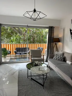 a living room with a couch and a table at Oasis by L'Oliveraie in Cannes