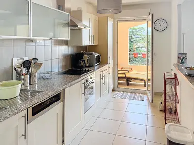 a kitchen with white cabinets and a counter top at 2 bedroom with pool 2 bathrooms 339 in Cannes