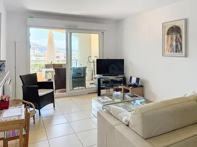 a living room with a couch and a television at 2 bedroom with pool 2 bathrooms 339 in Cannes