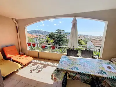 a balcony with a table and a large window at 2 bedroom with pool 2 bathrooms 339 in Cannes