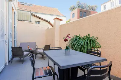 a patio with tables and chairs on a balcony at Bessons in Cannes