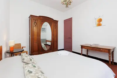 a bedroom with a bed and a dresser and a mirror at Bessons in Cannes