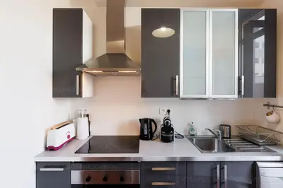 a kitchen with black and white cabinets and a sink at Bessons in Cannes