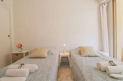a bedroom with two beds with pillows and a table at Le Navarre By ApiRent #Terrasse #Ascenseur #Wifi in Cannes