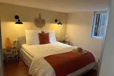 a bedroom with a bed with white sheets and red pillows at Spacious duplex near the city center of Cannes in Cannes