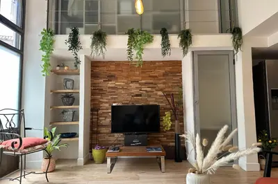 a living room with a tv and a brick wall at Spacious duplex near the city center of Cannes in Cannes
