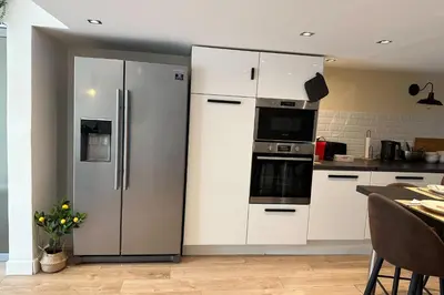 a kitchen with white cabinets and a refrigerator at Spacious duplex near the city center of Cannes in Cannes