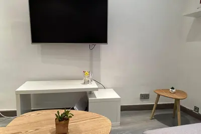 a room with a table and a tv on a wall at Charming T2 in the heart of city center in Cannes