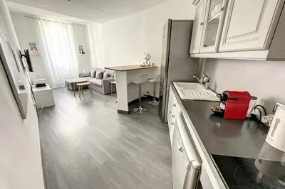 a kitchen with white cabinets and a red suitcase on the counter at Charming T2 in the heart of city center in Cannes