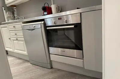 a stainless steel oven in a kitchen with white cabinets at Charming T2 in the heart of city center in Cannes