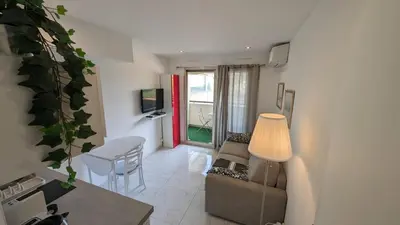 a living room with a couch and a table at Studio neuf centre Cannes 500 m plage in Cannes