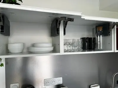 a kitchen cabinet with plates and dishes in it at Studio neuf centre Cannes 500 m plage in Cannes