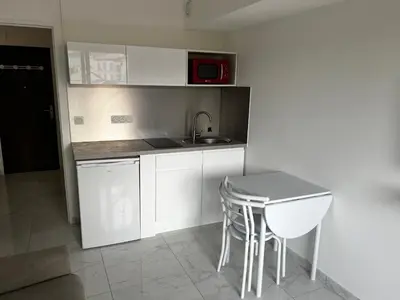 a small kitchen with a sink and a table at Studio neuf centre Cannes 500 m plage in Cannes