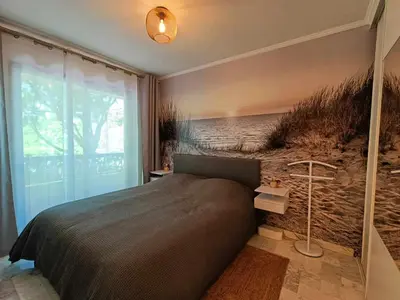 a bedroom with a bed with a painting on the wall at La Résidence Fleuries - Plage in Cannes