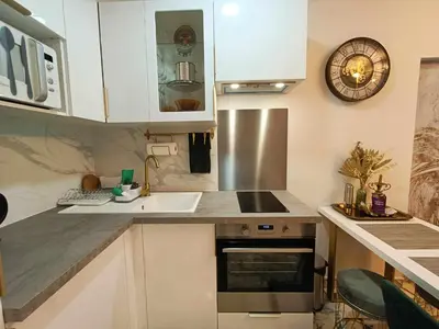 a kitchen with white cabinets and a sink at La Résidence Fleuries - Plage in Cannes