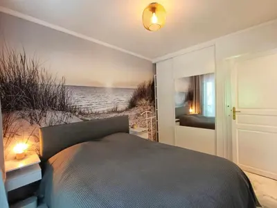 a bedroom with a bed and a view of the beach at La Résidence Fleuries - Plage in Cannes
