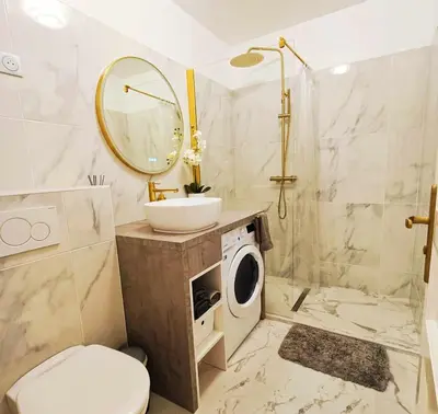a bathroom with a sink and a washing machine at La Résidence Fleuries - Plage in Cannes